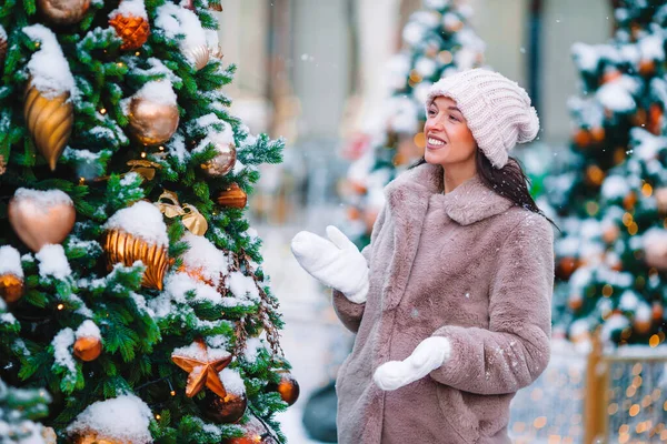 Happy girl near fir-tree branch in snow for New year. — Stock fotografie