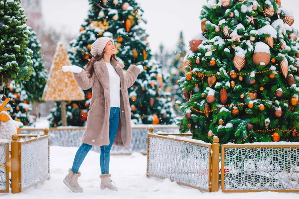 Happy girl near fir-tree branch in snow for New year. — Stock fotografie