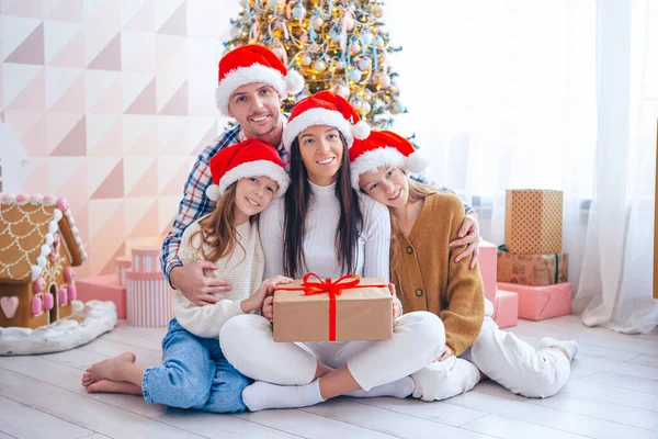Feliz familia joven con niños sosteniendo regalos de Navidad —  Fotos de Stock