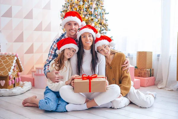 Šťastná mladá rodina s dětmi drží vánoční dárky — Stock fotografie