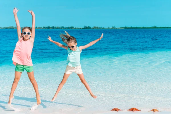 Underbara små flickor har mycket roligt på stranden. — Stockfoto