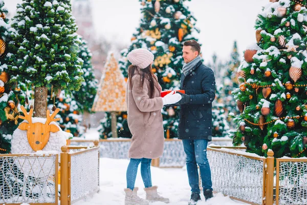 Joven hermosa pareja alegre celebrando la Navidad en la calle de la ciudad — Foto de Stock