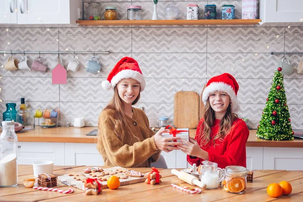 Dívky dělat vánoční perník dům u krbu ve zdobeném obývacím pokoji. — Stock fotografie