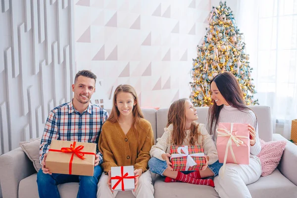 Feliz familia joven con niños sosteniendo regalos de Navidad — Foto de Stock