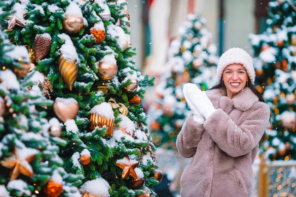 Happy girl near fir-tree branch in snow for New year. — Stock fotografie