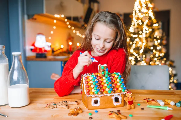 Niña haciendo casa de jengibre de Navidad en la cocina — Foto de Stock