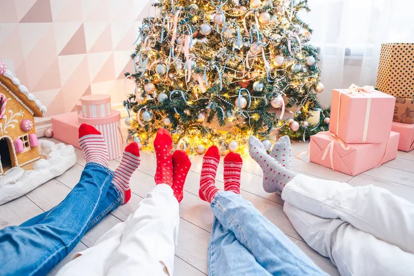 Foto de cerca de los pies de la familia en calcetines de lana junto al árbol de Navidad —  Fotos de Stock