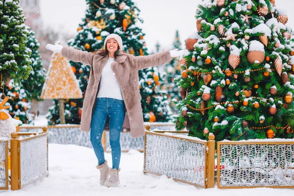 Happy girl near fir-tree branch in snow for New year. — Stock fotografie