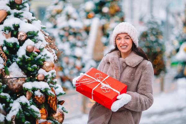 Happy girl near fir-tree branch in snow for New year. — Stock fotografie