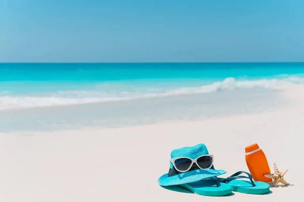 Butelki z kremem do opalania, okulary przeciwsłoneczne i rozgwiazdy na białym piasku plaża tło ocean — Zdjęcie stockowe