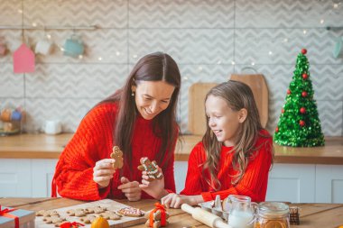 Mutlu aile annesi ve kızı Noel için kurabiye pişirir.