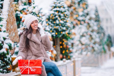 Mutlu kız yılbaşı için karların içinde köknar ağacı dalının yanında.