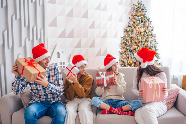 Feliz familia joven con niños sosteniendo regalos de Navidad —  Fotos de Stock