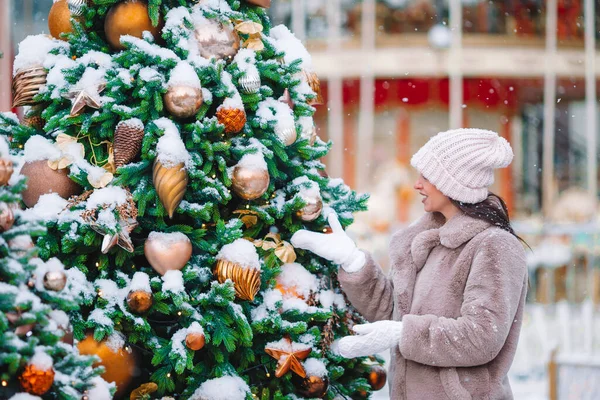 La muchacha feliz cerca de la rama del abeto en la nieve para un nuevo año. —  Fotos de Stock