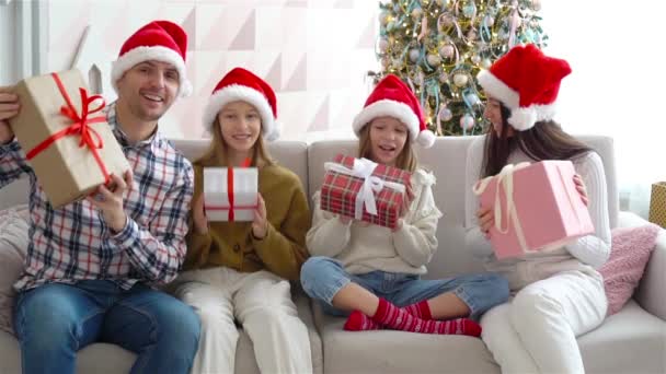 Счастливая молодая семья с детьми с подарками на Новый год — стоковое видео