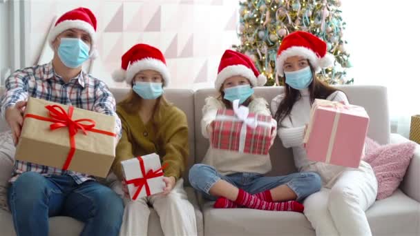 Feliz familia joven con niños sosteniendo regalos de Navidad — Vídeo de stock