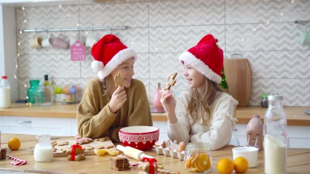 Meninas fazendo casa de gengibre de Natal na lareira na sala de estar decorada. — Vídeo de Stock