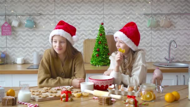 Niñas haciendo casa de jengibre de Navidad en la chimenea en la sala de estar decorada. — Vídeos de Stock