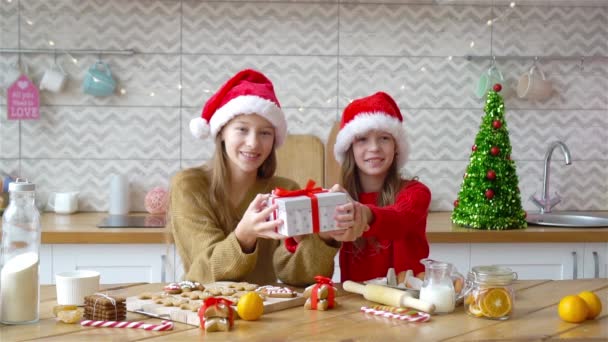 Små flickor gör jul pepparkakshus i köket — Stockvideo