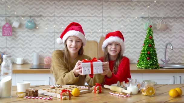 Små flickor gör jul pepparkakshus i köket — Stockvideo