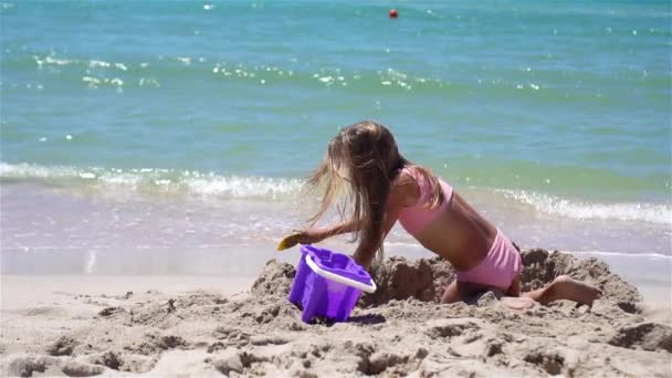 Gadis kecil di pantai putih tropis membuat istana pasir — Stok Video