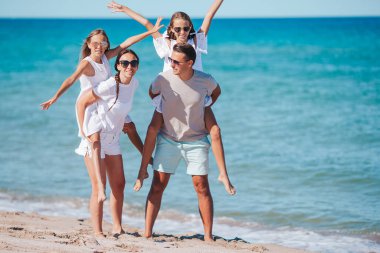 Yaz tatili boyunca sahilde mutlu bir aile.