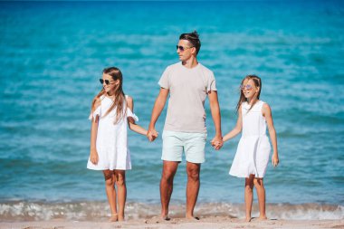 Tropik bir sahil tatilinde mutlu ve güzel bir aile.