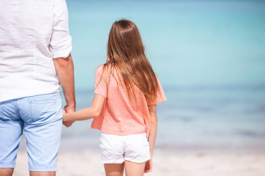 Küçük kız ve mutlu baba kumsal tatili boyunca eğleniyorlar.