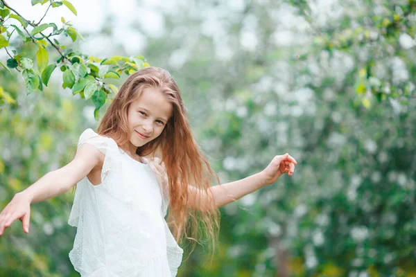 美丽的春日，在盛开的苹果园里，可爱的小女孩 — 图库照片
