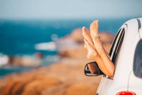 Primo piano di piedi bambina mostrando dal finestrino della macchina — Foto Stock