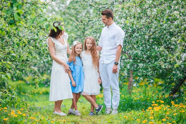 Adorable family in blooming cherry garden on beautiful spring day — Stock Photo, Image