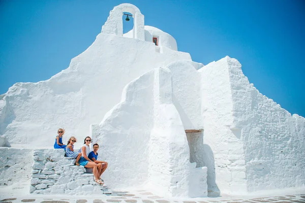 Rodzinne wakacje w Europie. Rodzice i dzieci na ulicy typowej greckiej tradycyjnej wsi z białymi ścianami i kolorowymi drzwiami na wyspie Mykonos — Zdjęcie stockowe