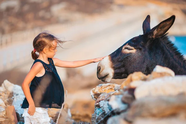 Mykonos adasında eşekli küçük bir kız. — Stok fotoğraf