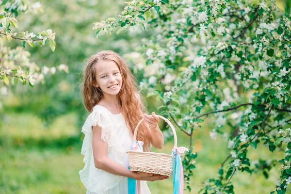 Adorable niña en el jardín de manzanas en flor en hermoso día de primavera —  Fotos de Stock