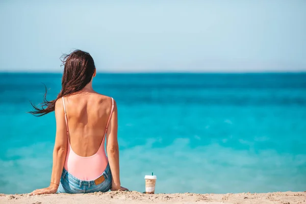 Młoda piękna kobieta z kawą na plaży podczas tropikalnych wakacji — Zdjęcie stockowe