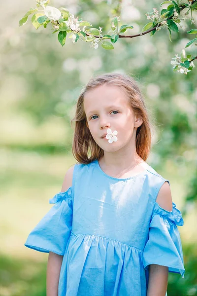 Adorável menina no jardim de maçã florescendo no belo dia de primavera — Fotografia de Stock