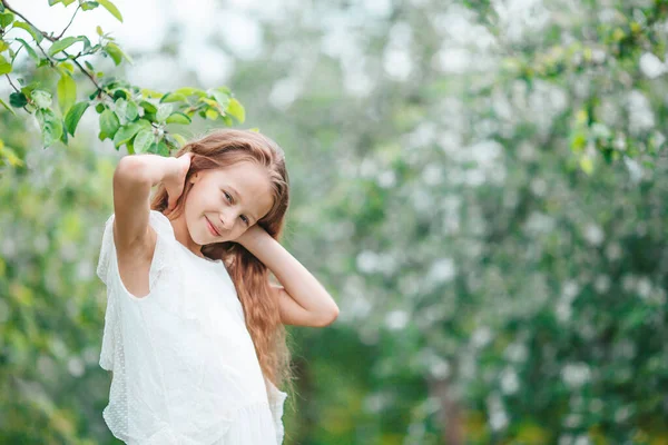 Çiçekli elma bahçesinde küçük sevimli bir kız güzel bir bahar günü — Stok fotoğraf