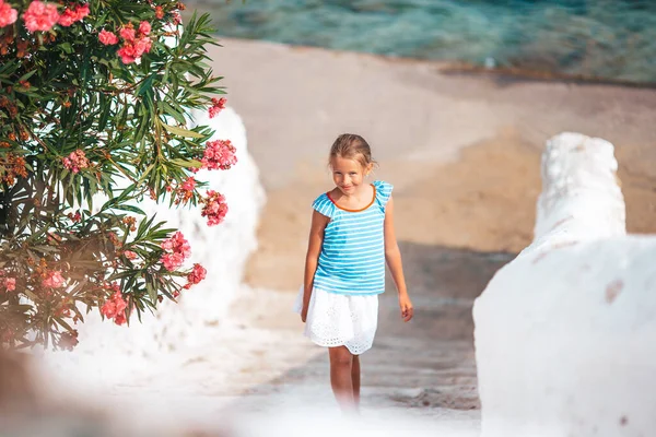 Adorable niña en la vieja calle del típico pueblo tradicional griego — Foto de Stock