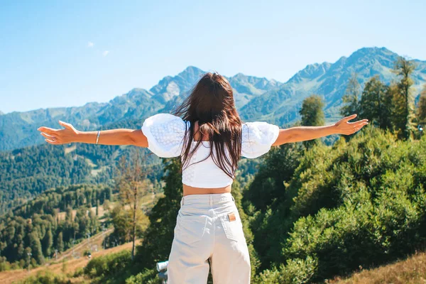 Mulher jovem feliz bonita em montanhas no fundo do nevoeiro — Fotografia de Stock