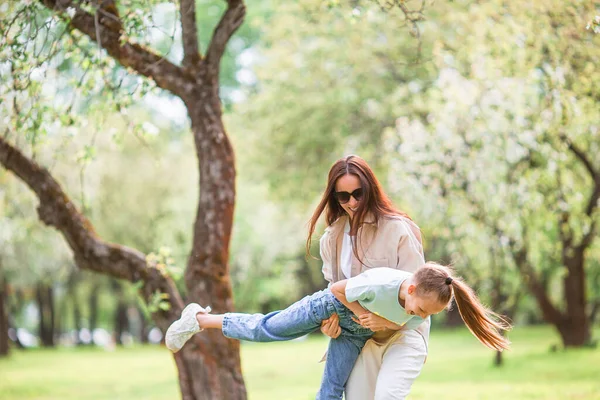 Familj till mor och dotter i blommande körsbärsträdgård — Stockfoto