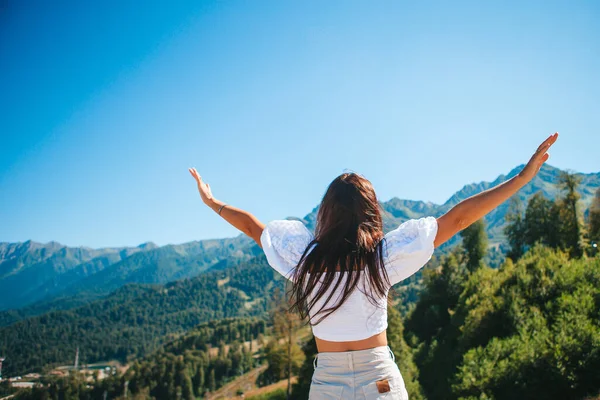 Mulher jovem feliz bonita em montanhas no fundo do nevoeiro — Fotografia de Stock