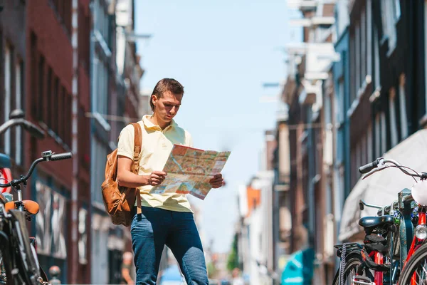 Gelukkige jongeman met een stadsplattegrond in de Europese stad — Stockfoto