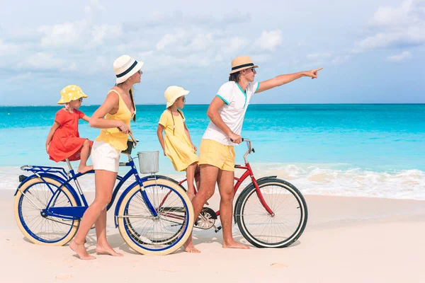 Family with a bike on tropical beach — Stock Photo, Image