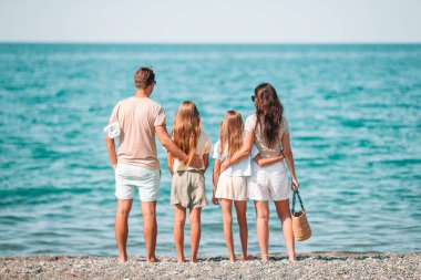 Yaz tatili boyunca sahilde mutlu bir aile.