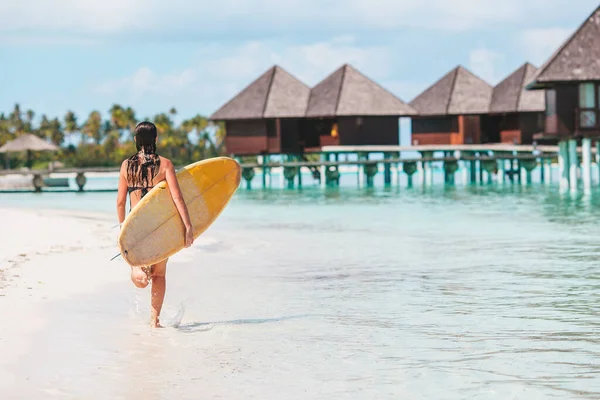 Mooie surfer vrouw klaar om te surfen in turquoise zee, op stand up paddle board op exotische vakantie Stockfoto