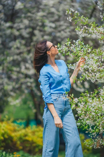 Schöne Frau genießt Duft im Frühlingskirschgarten — Stockfoto