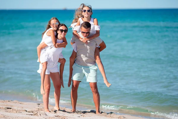 Familia feliz en la playa durante las vacaciones de verano — Foto de Stock