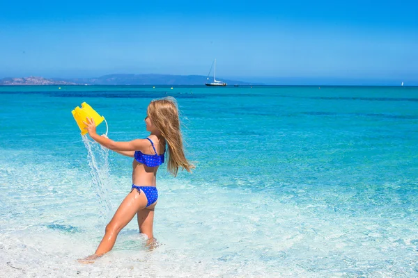 Adorable niña se divierten en aguas poco profundas en la playa tropical —  Fotos de Stock