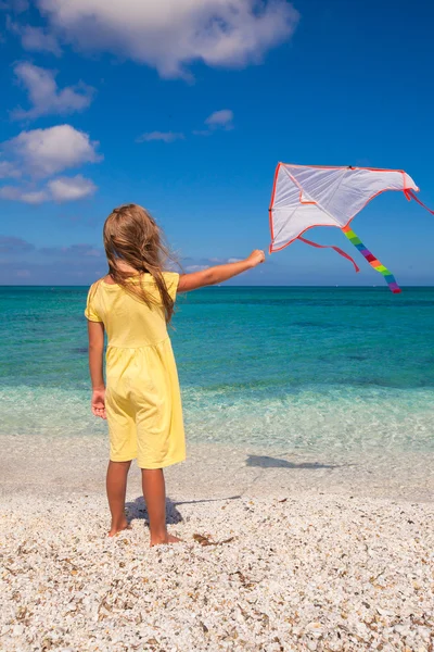 Petite fille mignonne jouant avec cerf-volant volant sur la plage tropicale — Photo