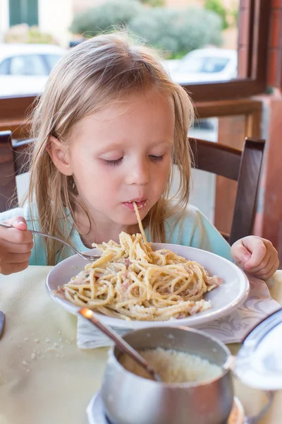 Adorable niña comiendo espaguetis al aire libre restaraunt —  Fotos de Stock